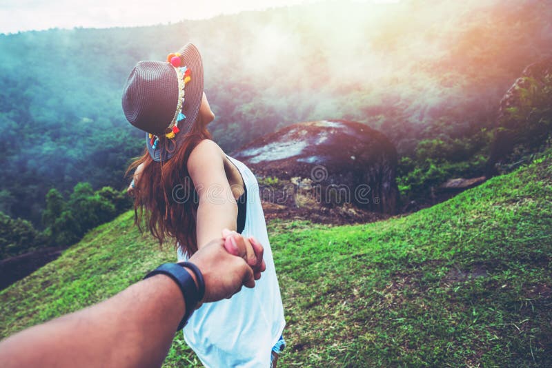 Donne e uomini amanti asiatici viaggiano rilassati in vacanza Mani in corsa sul prato Legno naturale selvatico sulla montagna fotografia stock libera da diritti