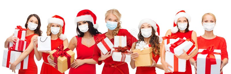 Donne felici in maschere mediche con regali di natale
