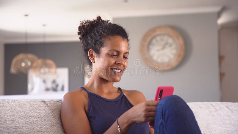 Donne miste sorridenti che usano smartphone a casa