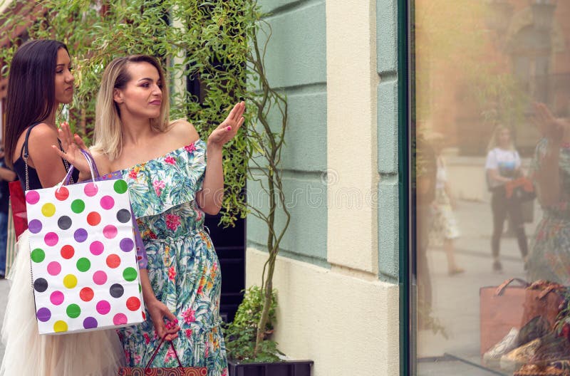 Donne nell'acquisto che esamina la finestra del negozio nella città fotografia stock libera da diritti Donne nell'acquisto che esamina la finestra del negozio nella città fotografia stock libera da diritti