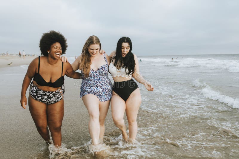 Donne più allegre di dimensione che godono della spiaggia