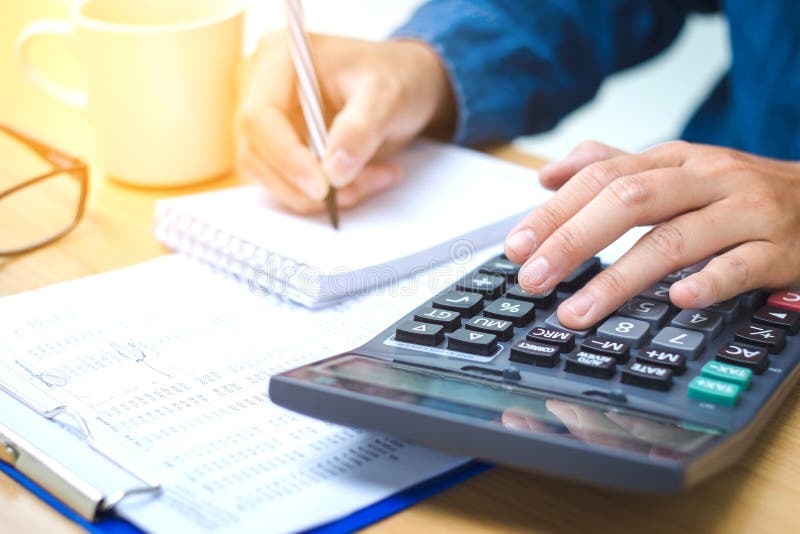 Données financières analysant l'écriture de main et comptant sur la calculatrice photo libre de droits Données financières analysant l'écriture de main et comptant sur la calculatrice photo libre de droits