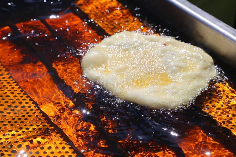 Donut frying in hot oil stock photo. Image of orange 90298508