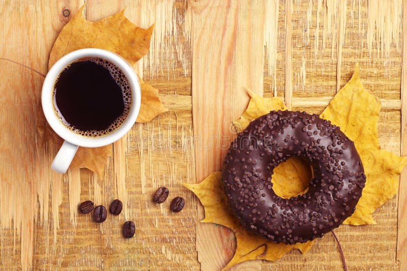 Donut, coffee and autumn leaves