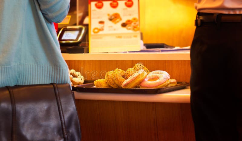 Donut on tray in counter shop, warm tone color, soft focus