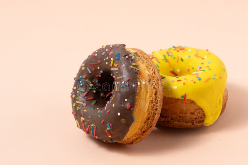 Donuts with colorful glaze on pastel beige background lizenzfreies stockfoto