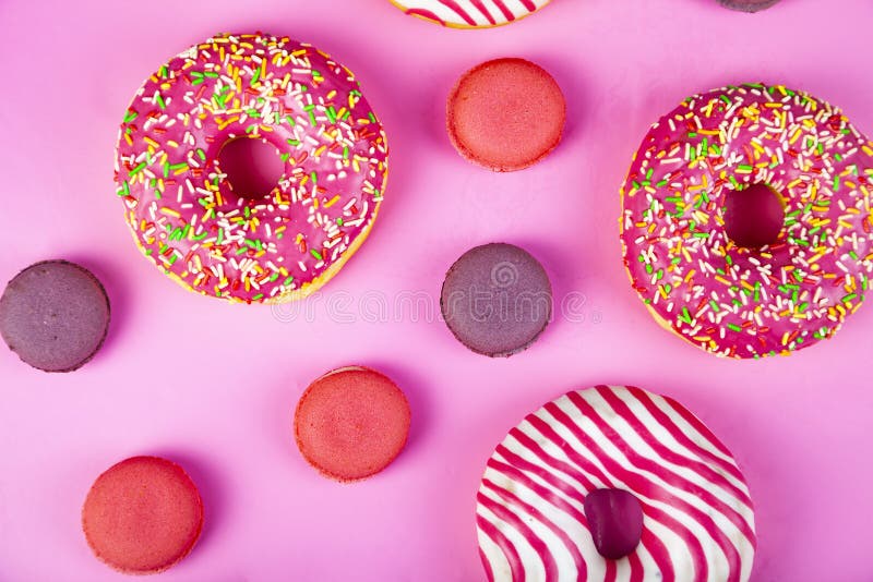 Donuts and macaroons on a pink background. Delicious desser Delicious dessert.