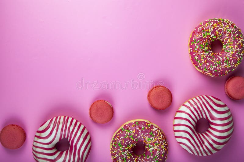 Donuts and macaroons on a pink background. Delicious desser Delicious dessert.