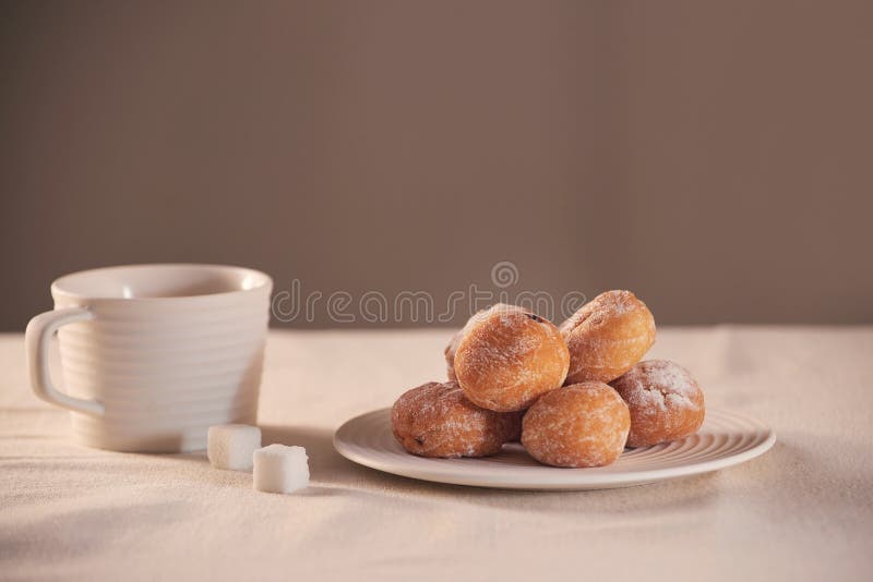 Donuts med socker på platta- och kaffekoppen på vit bakgrund arkivfoton Donuts med socker på platta- och kaffekoppen på vit bakgrund arkivfoton