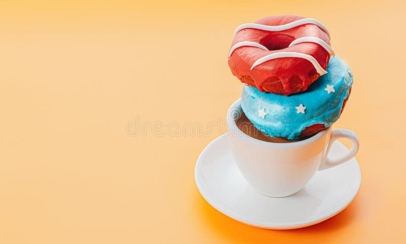 Donuts one with blue icing and white stars and with red icing and white stripes and a cup of coffee on a yellow background