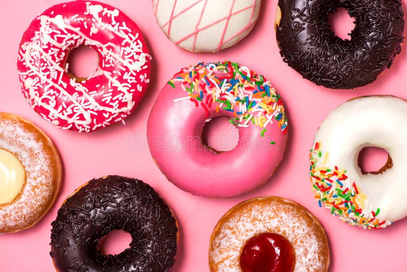 Donuts с замороженностью на предпосылке пастельного пинка donuts сладостные стоковые фото Donuts с замороженностью на предпосылке пастельного пинка donuts сладостные стоковые фото