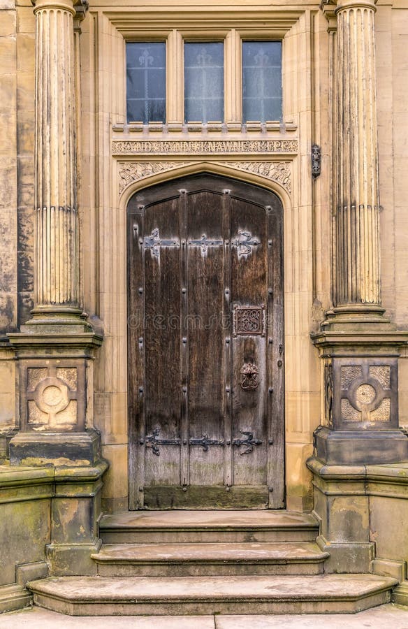 A medieval brown wooden door with columns.