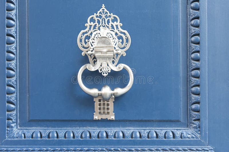 Doorknocker branco em uma porta azul fotografia de stock Doorknocker branco em uma porta azul fotografia de stock