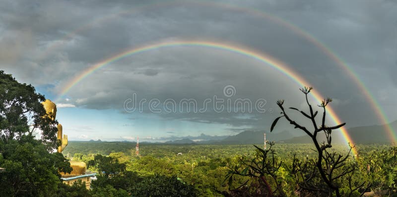 Doppio arcobaleno pieno e Buddha dorato fotografia stock libera da diritti