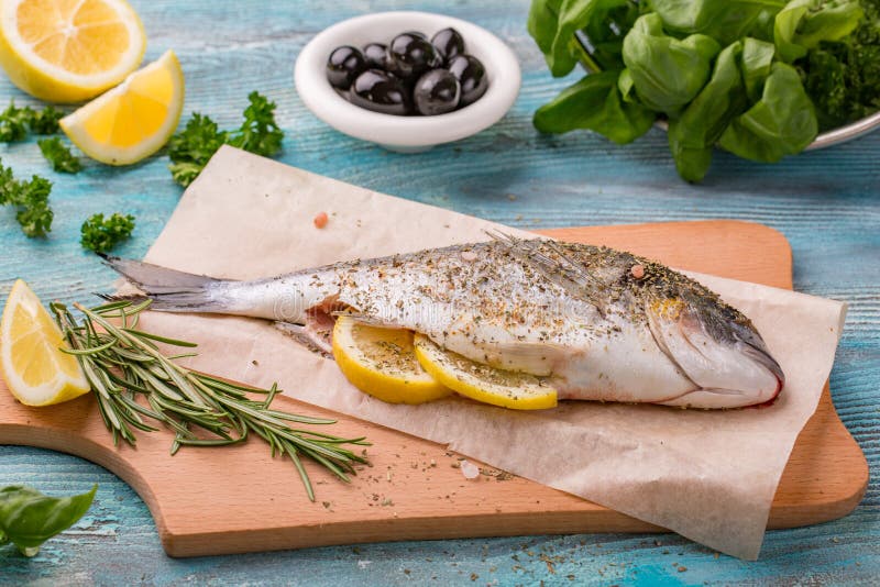 Dorado свежих рыб Пряная специя травы и еды овощей здоровая на черный каменный варить доски стоковое изображение Dorado свежих рыб Пряная специя травы и еды овощей здоровая на черный каменный варить доски стоковое изображение