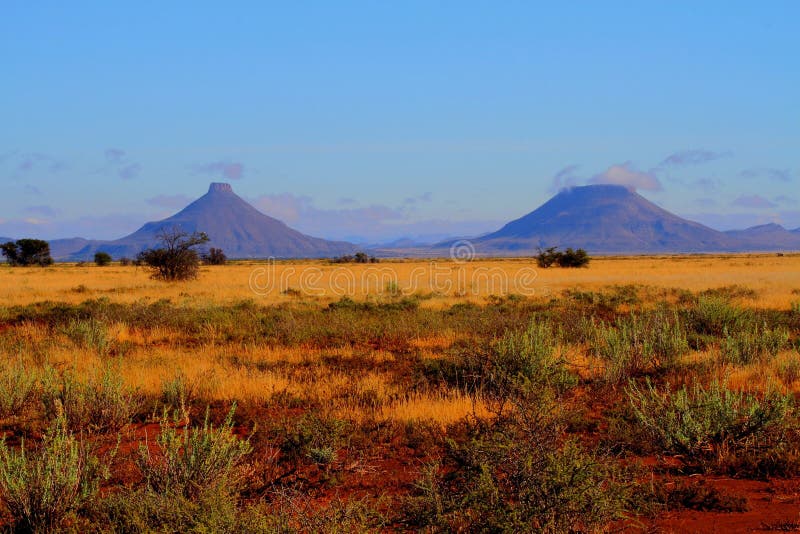 Affioramenti rocciosi in Karoo regione naturale del Sud Africa sono nuvole basse che assomiglia fumo da vulcani dormienti al di sopra di loro orizzonte in formato orizzontale.