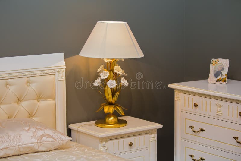 Dormitorio blanco real de lujo en estilo antiguo Mesita de noche con una lámpara elegante imagenes de archivo Dormitorio blanco real de lujo en estilo antiguo Mesita de noche con una lámpara elegante imagenes de archivo
