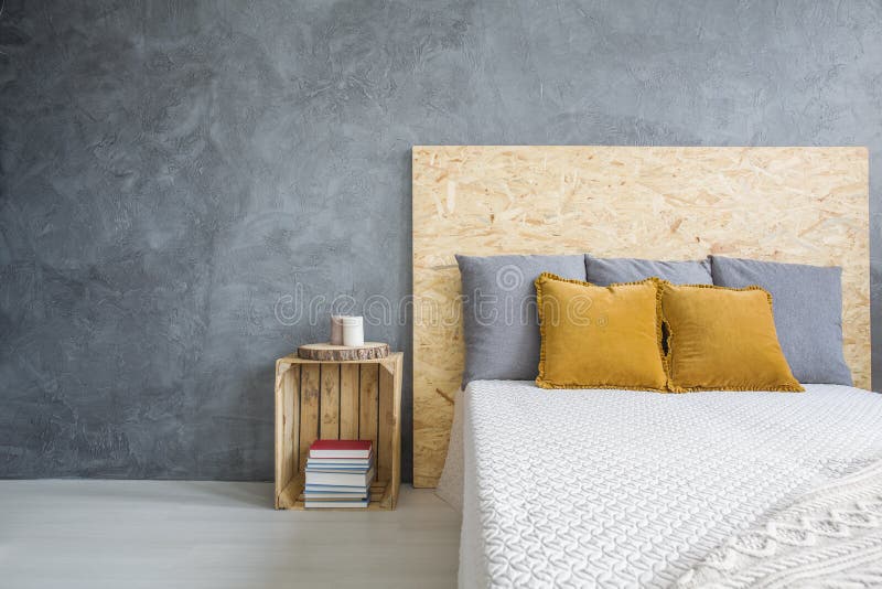 Dormitorio gris con la cama de OSB imágenes de archivo libres de regalías