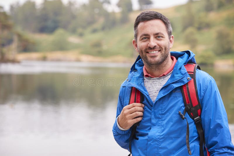 Dorosły mężczyzna stoi bezczynnie jezioro ono uśmiecha się kamera na campingowym wakacje, portret, Jeziorny okręg, UK