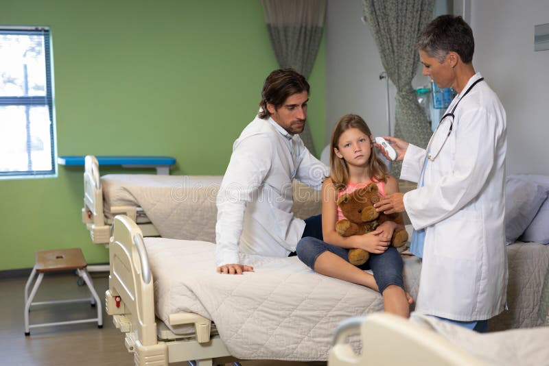 Dorośleć kobieta doktorski używa otoskop dla sprawdza dziewczyny ucho przy szpitalem zdjęcie stock Dorośleć kobieta doktorski używa otoskop dla sprawdza dziewczyny ucho przy szpitalem zdjęcie stock