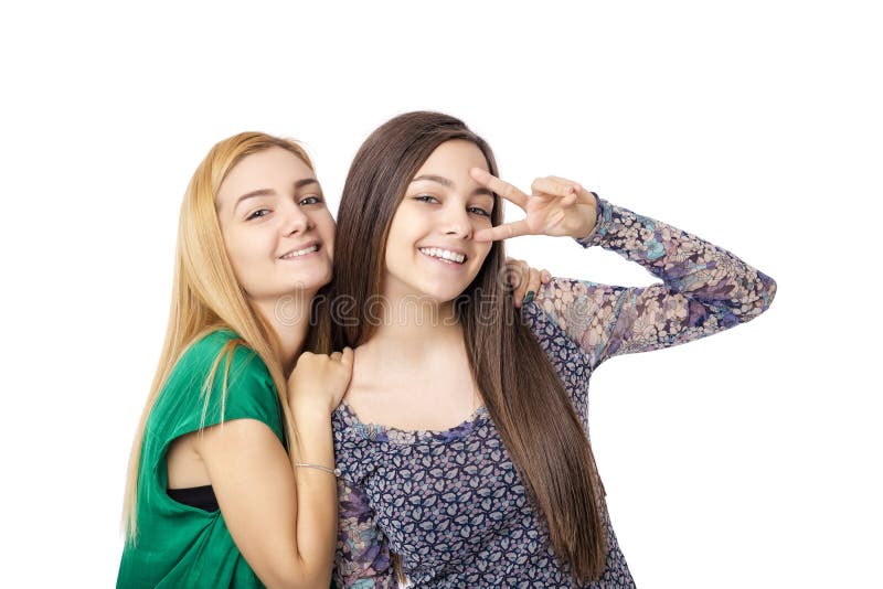 Dos adolescentes bonitos que presentan y que muestran dos fingeres imagenes de archivo Dos adolescentes bonitos que presentan y que muestran dos fingeres imagenes de archivo