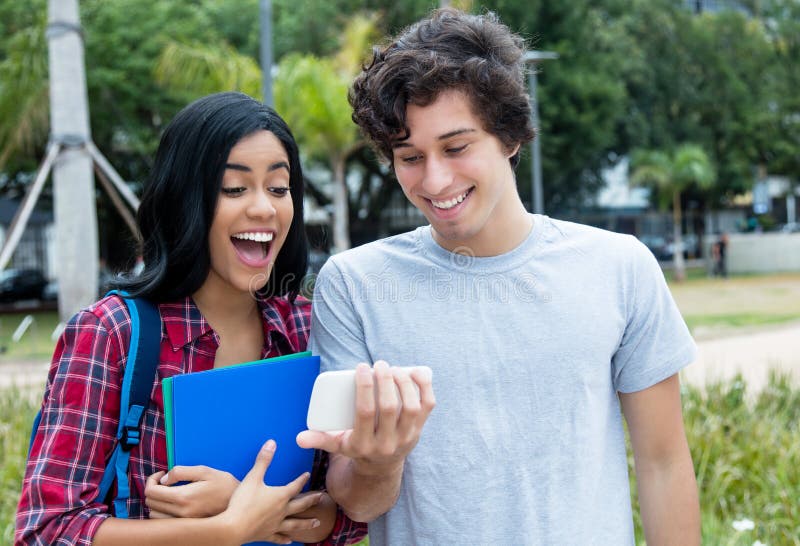 Dos adultos jovenes que miran el videoclip en el teléfono móvil imágenes de archivo libres de regalías Dos adultos jovenes que miran el videoclip en el teléfono móvil imágenes de archivo libres de regalías
