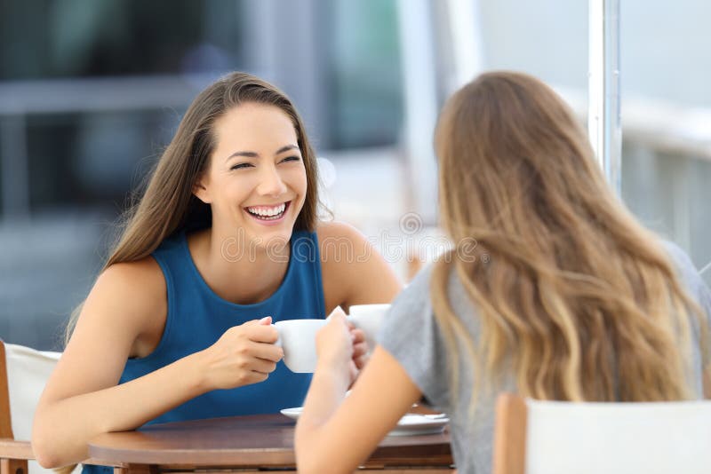 Dos amigos felices que hablan en una terraza del restaurante imágenes de archivo libres de regalías Dos amigos felices que hablan en una terraza del restaurante imágenes de archivo libres de regalías