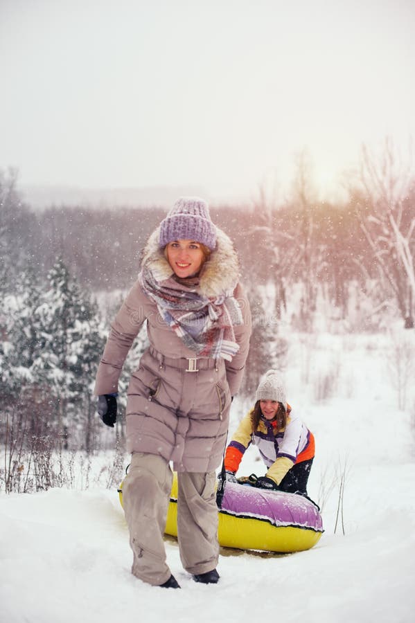 Dos amigos femeninos que se divierten en la colina de la nieve fotografía de archivo Dos amigos femeninos que se divierten en la colina de la nieve fotografía de archivo