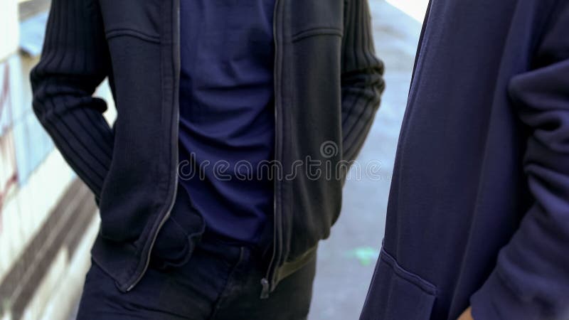 Dos amigos masculinos en ropa casual que comunican, manos en bolsillos se cierran para arriba imagenes de archivo Dos amigos masculinos en ropa casual que comunican, manos en bolsillos se cierran para arriba imagenes de archivo