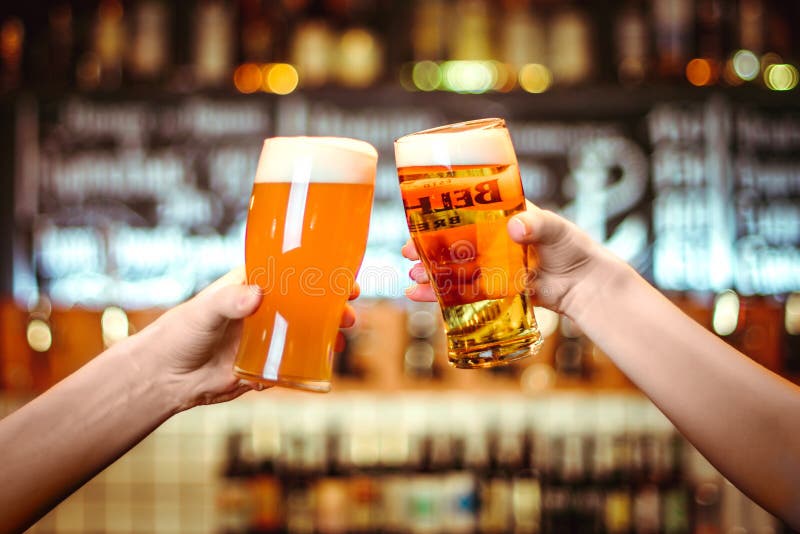 Dos amigos que tuestan con los vidrios de cerveza ligera en el pub Fondo hermoso del grano fino de Oktoberfest imagen de archivo libre de regalías Dos amigos que tuestan con los vidrios de cerveza ligera en el pub Fondo hermoso del grano fino de Oktoberfest imagen de archivo libre de regalías