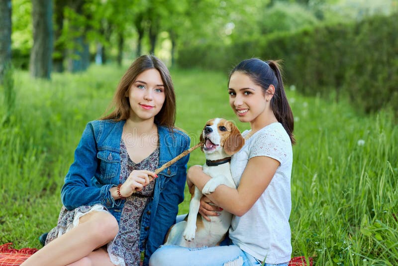 Dos amigos y beagles Mujer feliz joven dos, divirtiéndose en bergantín fotos de archivo libres de regalías Dos amigos y beagles Mujer feliz joven dos, divirtiéndose en bergantín fotos de archivo libres de regalías