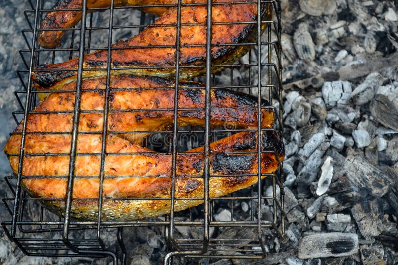 Dos asaron a la parrilla los filetes de color salmón Carbones que un pedazo de filete de pescados apetitoso coció en carbones foto de archivo Dos asaron a la parrilla los filetes de color salmón Carbones que un pedazo de filete de pescados apetitoso coció en carbones foto de archivo
