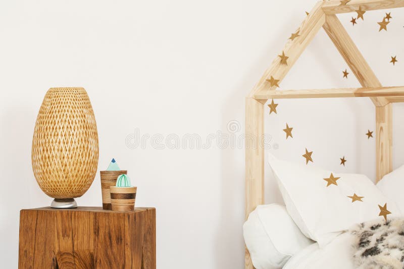 Dos cactus artificiales y lámpara de mimbre que se colocan en bedsi de madera fotografía de archivo Dos cactus artificiales y lámpara de mimbre que se colocan en bedsi de madera fotografía de archivo
