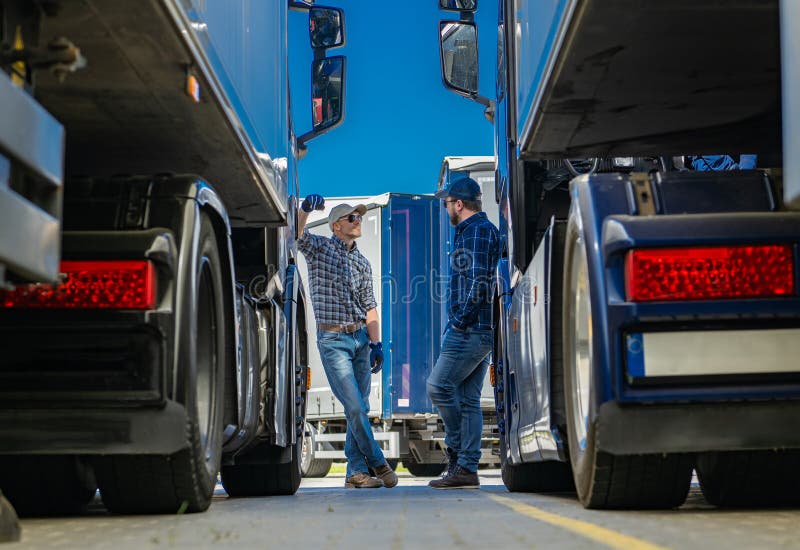 Dos camioneros hablando de negocios frente a un semirremolque fotografía de archivo