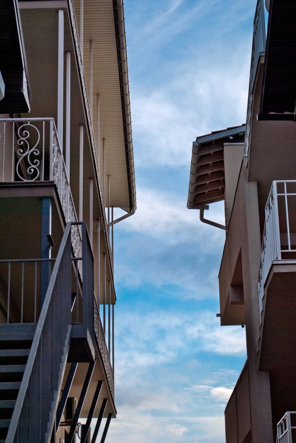 Dos casas se oponen de lado a lado, los balcones, escaleras, tejados, al cielo azul imagenes de archivo Dos casas se oponen de lado a lado, los balcones, escaleras, tejados, al cielo azul imagenes de archivo