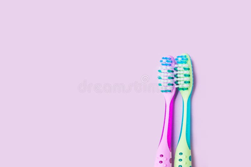 Dos cepillos de dientes para un par en púrpura en colores pastel foto de archivo libre de regalías Dos cepillos de dientes para un par en púrpura en colores pastel foto de archivo libre de regalías