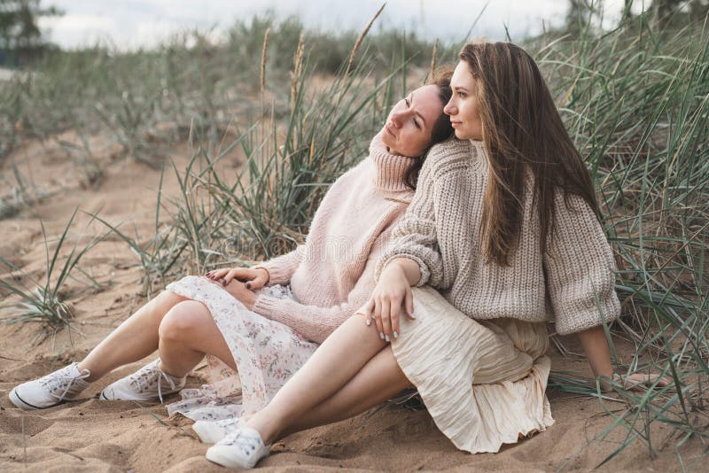 Dos chicas hermosas descansan sobre la hierba. las hermanas hablan mentalmente y recuerdan su infancia. dos amigos cercanos disfru imagen de archivo