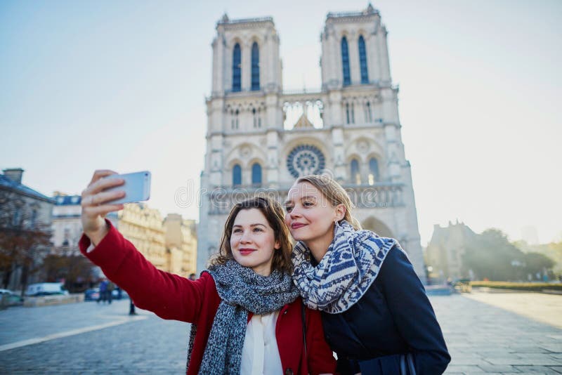 Dos chicas jóvenes que toman el selfie cerca de Notre-Dame en París fotos de archivo Dos chicas jóvenes que toman el selfie cerca de Notre-Dame en París fotos de archivo
