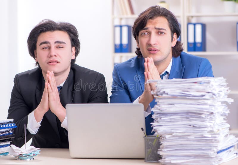 Dos colegas hombres descontentos con el excesivo trabajo fotos de archivo libres de regalías