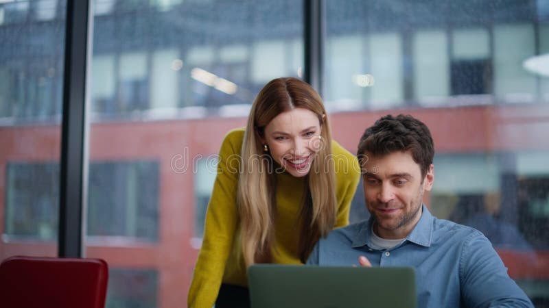 Dos colegas videollamando desde una laptop en el armario de la oficina. Camareros sonrientes fotografía de archivo libre de regalías