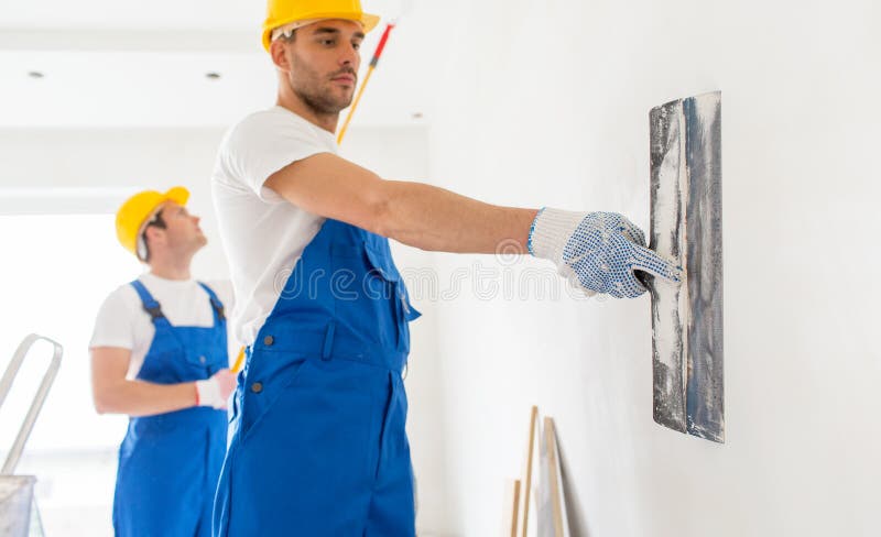 Dos constructores con las herramientas de la pintura que reparan el sitio imagen de archivo Dos constructores con las herramientas de la pintura que reparan el sitio imagen de archivo