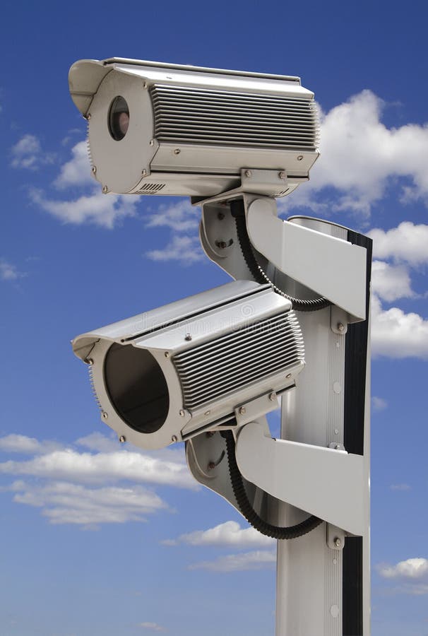 Two security surveillance cameras on blue sky, isolated with clipping path. Two security surveillance cameras on blue sky, isolated with clipping path