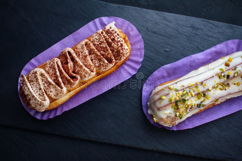 Dos deliciosos pasteles de eclair con sabor a tiramisú y pistacho foto de archivo libre de regalías