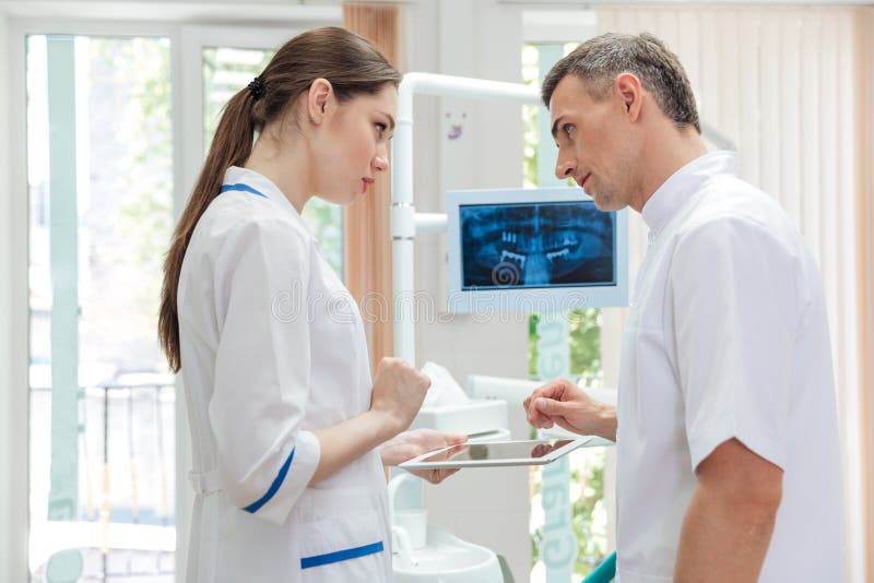 Two doctors dentists looking panoramic photo of teeth on the monitor in clinic. Two doctors dentists looking panoramic photo of teeth on the monitor in clinic