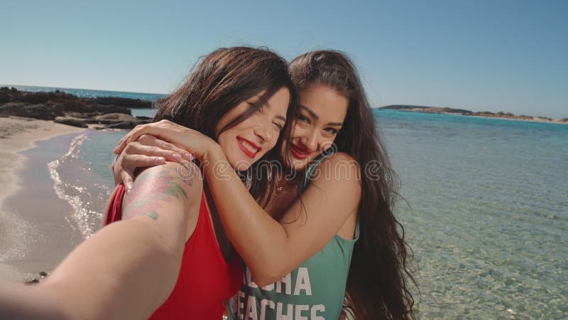 Dos encantadoras novias lesbianas divirtiéndose en la playa Lesbiana, LGBT, amistad, viajes, concepto de relación