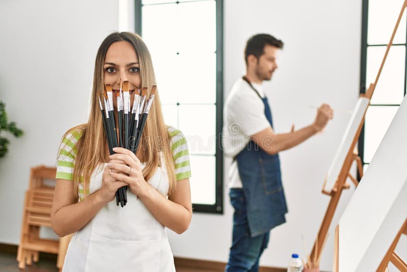 Dos estudiantes hispanos sonriendo alegre pintura en el estudio de arte fotos de archivo