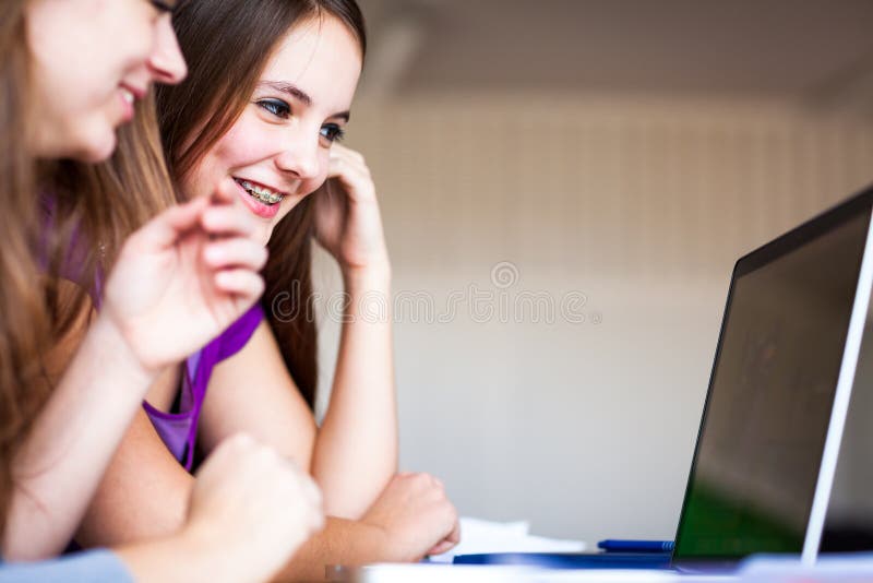 Dos estudiantes universitarios de sexo femenino que trabajan en un ordenador portátil durante imagen de archivo Dos estudiantes universitarios de sexo femenino que trabajan en un ordenador portátil durante imagen de archivo