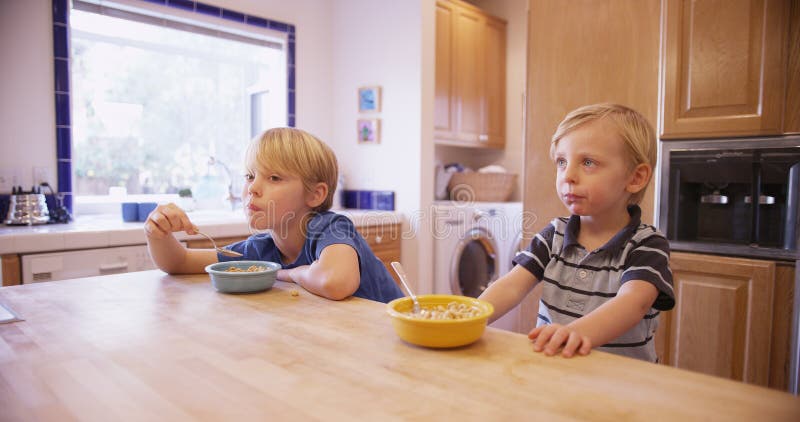 Dos hermanos hermosos jovenes que comen el cereal junto imagenes de archivo Dos hermanos hermosos jovenes que comen el cereal junto imagenes de archivo