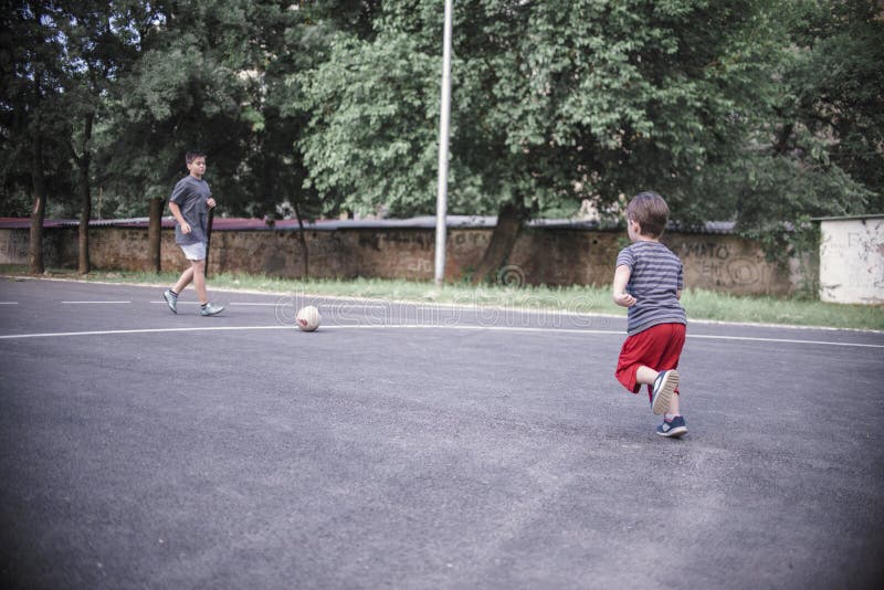 Dos hermanos que juegan a fútbol imagen de archivo libre de regalías Dos hermanos que juegan a fútbol imagen de archivo libre de regalías