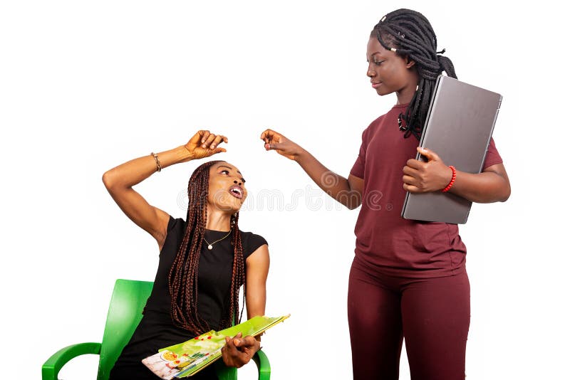 Dos hermosas alumnas felices con laptop y revista imagen de archivo libre de regalías